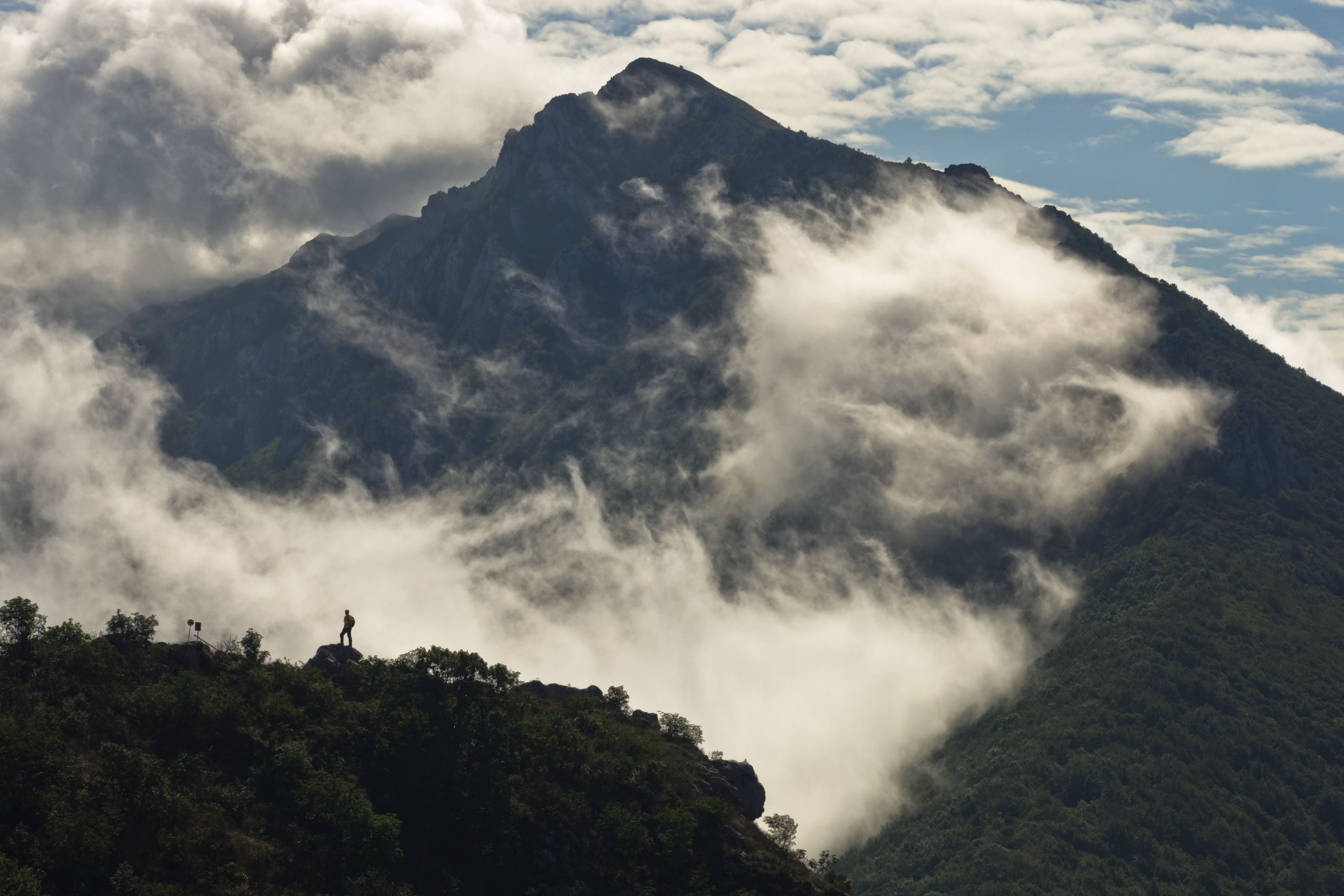 Hiker silhouette on Suva Planina with misty mountain backdrop